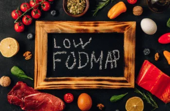 Fodmap Vs Gut Hpnotherapy for IBS relief Low FODMAP food board with chalkboard label, representing IBS dietary management options.